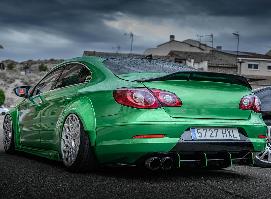 A green car showcasing its rear bumper, highlighting its sleek design and modern features.